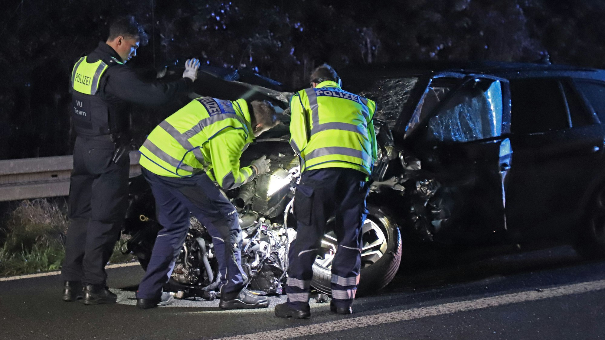 Einsatzkräfte der Polizei arbeiten an einem verunfallten Fahrzeug. Durch einen Geisterfahrer war es auf der A3 zu einem tödlichen Unfall gekommen.