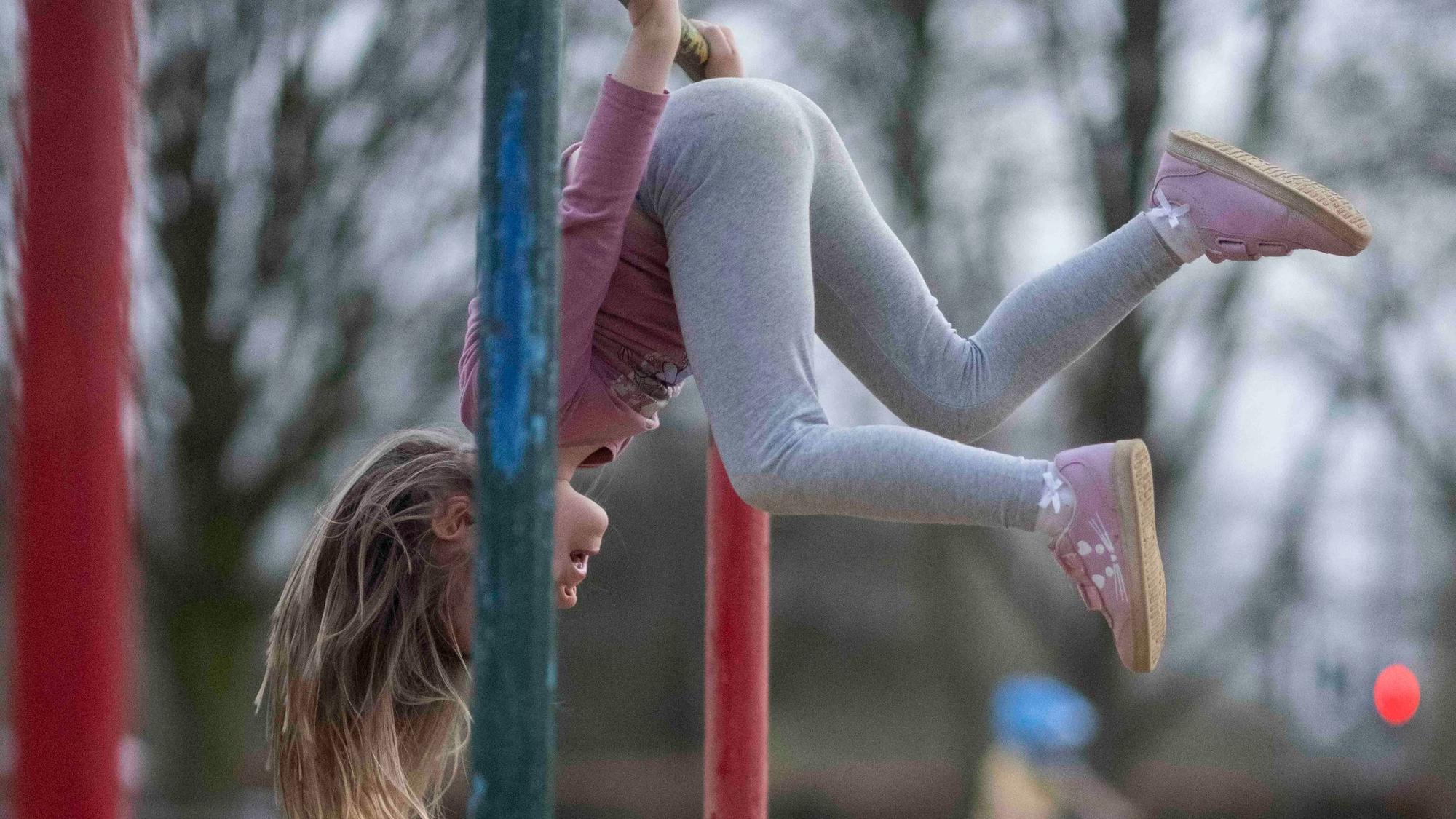 Ein Kind hängt kopfüber an einer Drehstange auf dem Spielplatz am Schillerpark in Euskirchen.