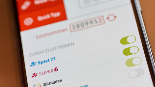 Ein Handy liegt auf einem Tisch. Auf dem Handybildschirm ist die WestLotto App zu sehen.