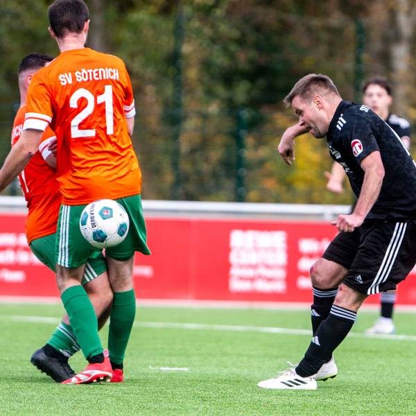 Michael Jansen spielt einen Ball hinter dem Rücken zweier Sötenicher Spieler, die sich gegenseitig behindern.
