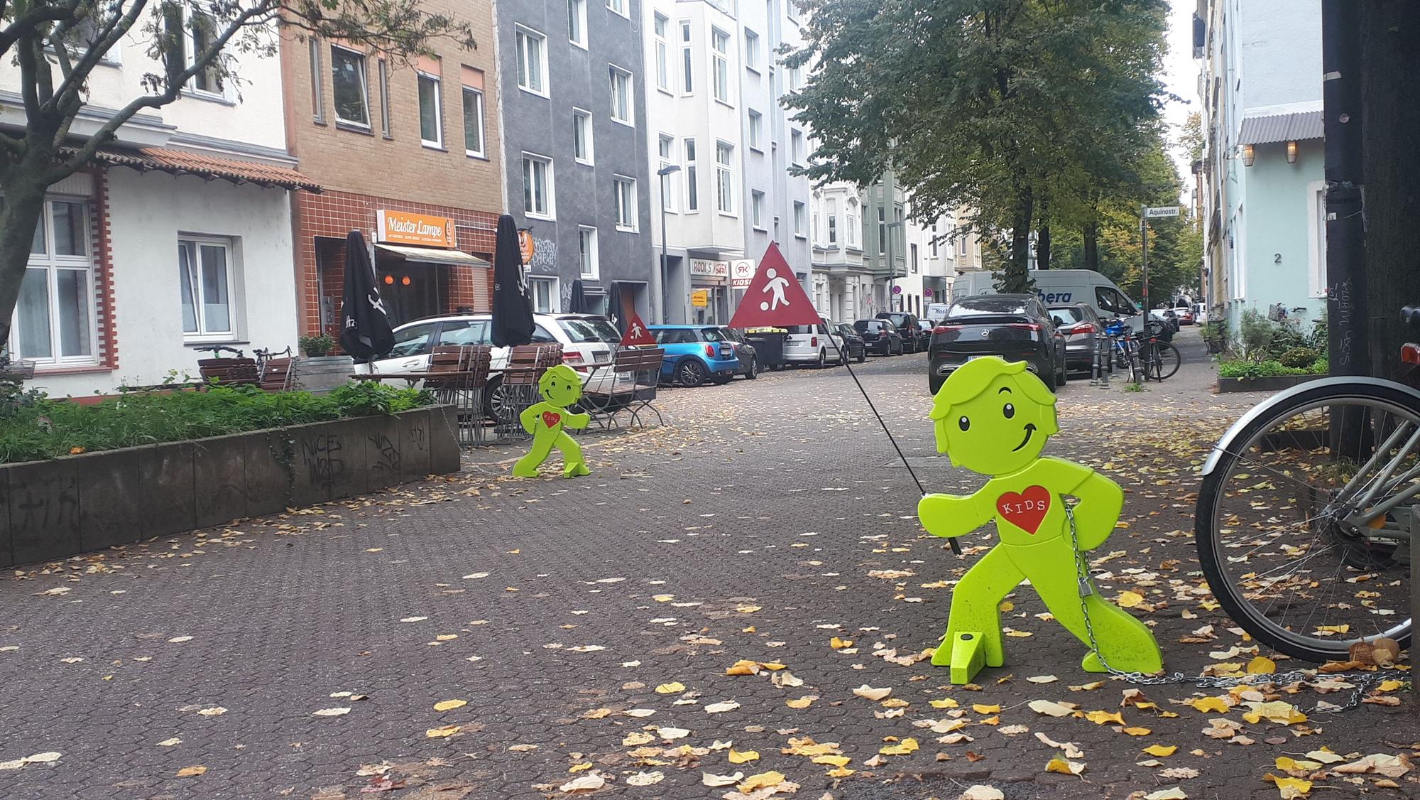 Dezente Erinnerung: Die gelben Brems-Aufstellfiguren erinnern an die Spielstraße und langsames Fahren.