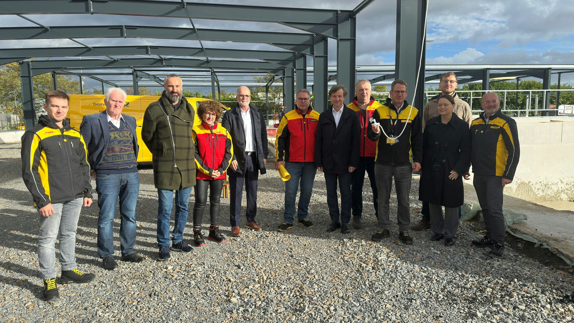 Eine Gruppe von Menschen steht unter einer Stahlkonstruktion.