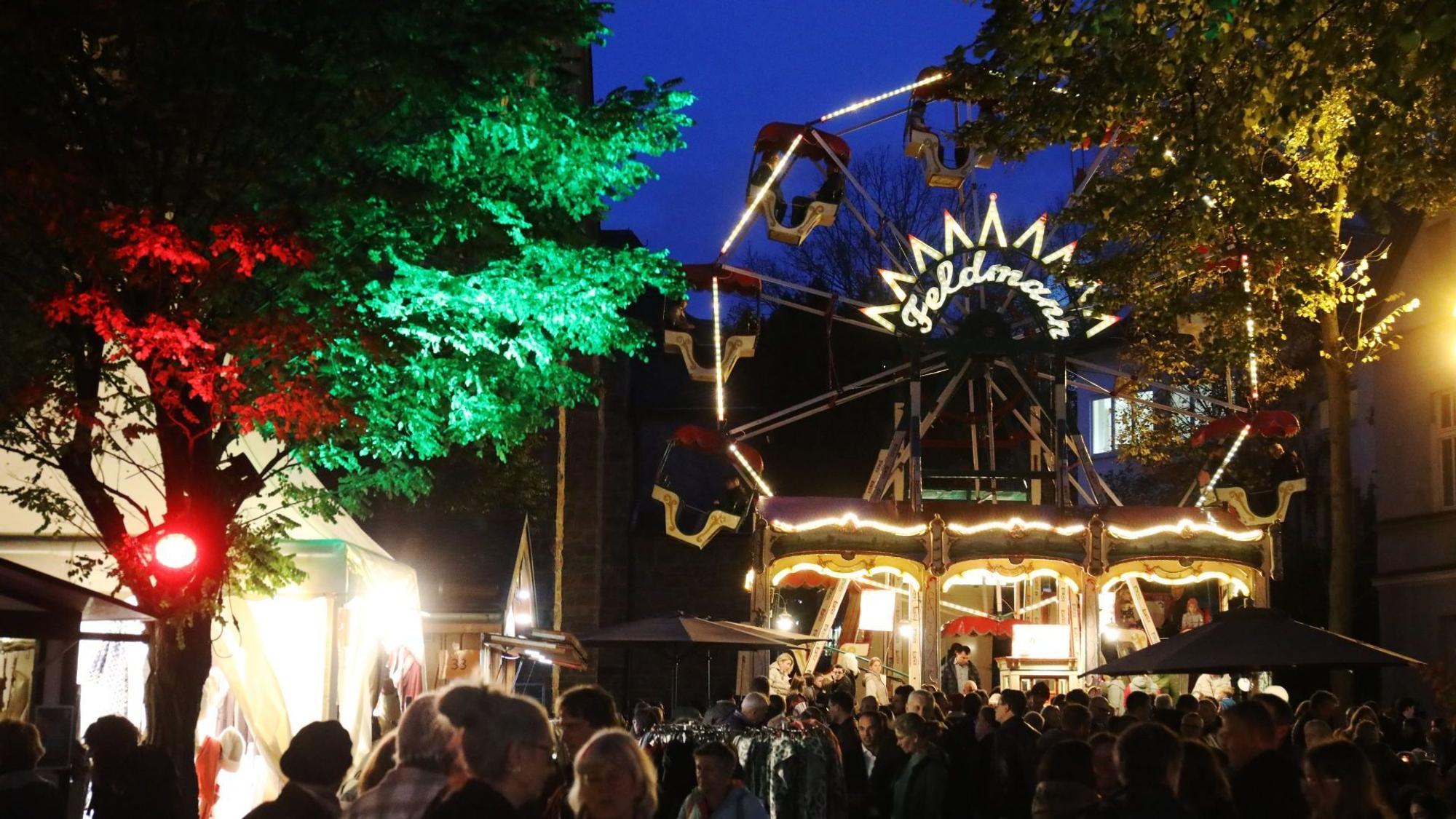 Menschen auf dem Martini-Markt in Bad Honnef, im Hintergrund ein Riesenrad.