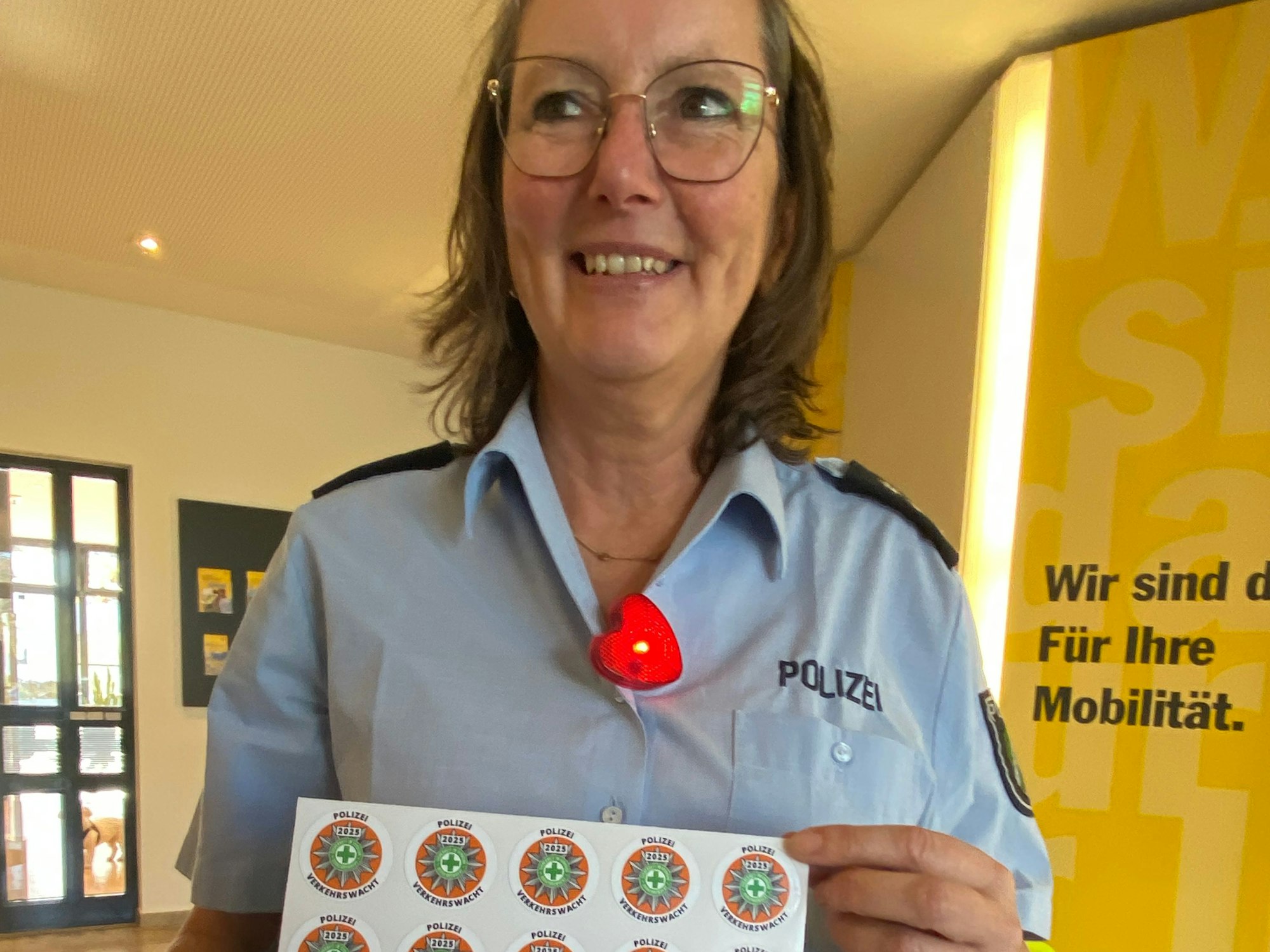Lydia Hüpgen zeigt einen Bogen mit Plaketten, die auf die Fahrräder der Kinder geklebt werden.