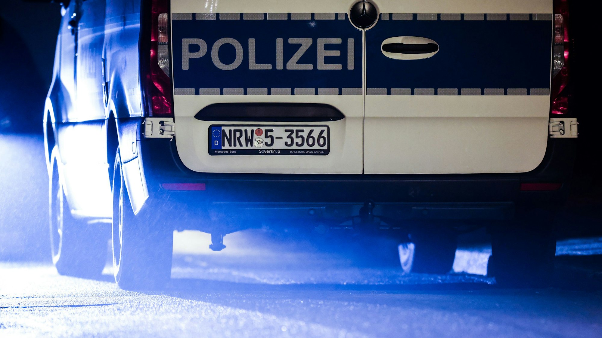 Ein Polizeiauto steht bei einem abendlichen Einsatz der Ermittler auf der Straße.