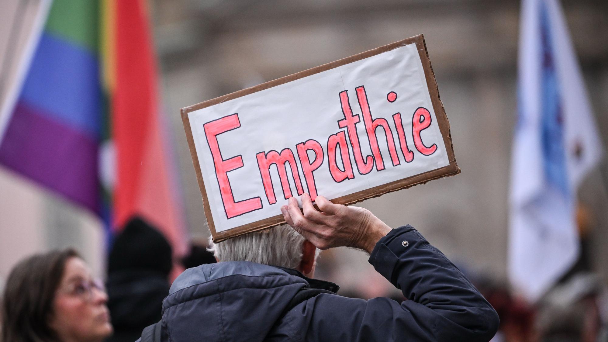 Ein Mann hält bei einer Demonstration ein Schild mit der Aufschrift