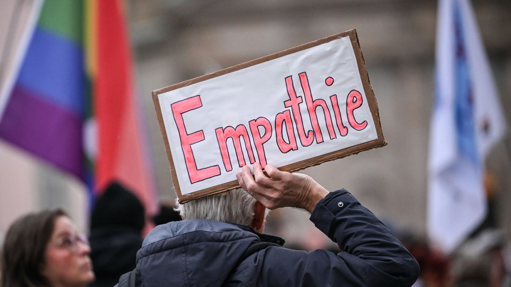 Ein Mann hält bei einer Demonstration ein Schild mit der Aufschrift