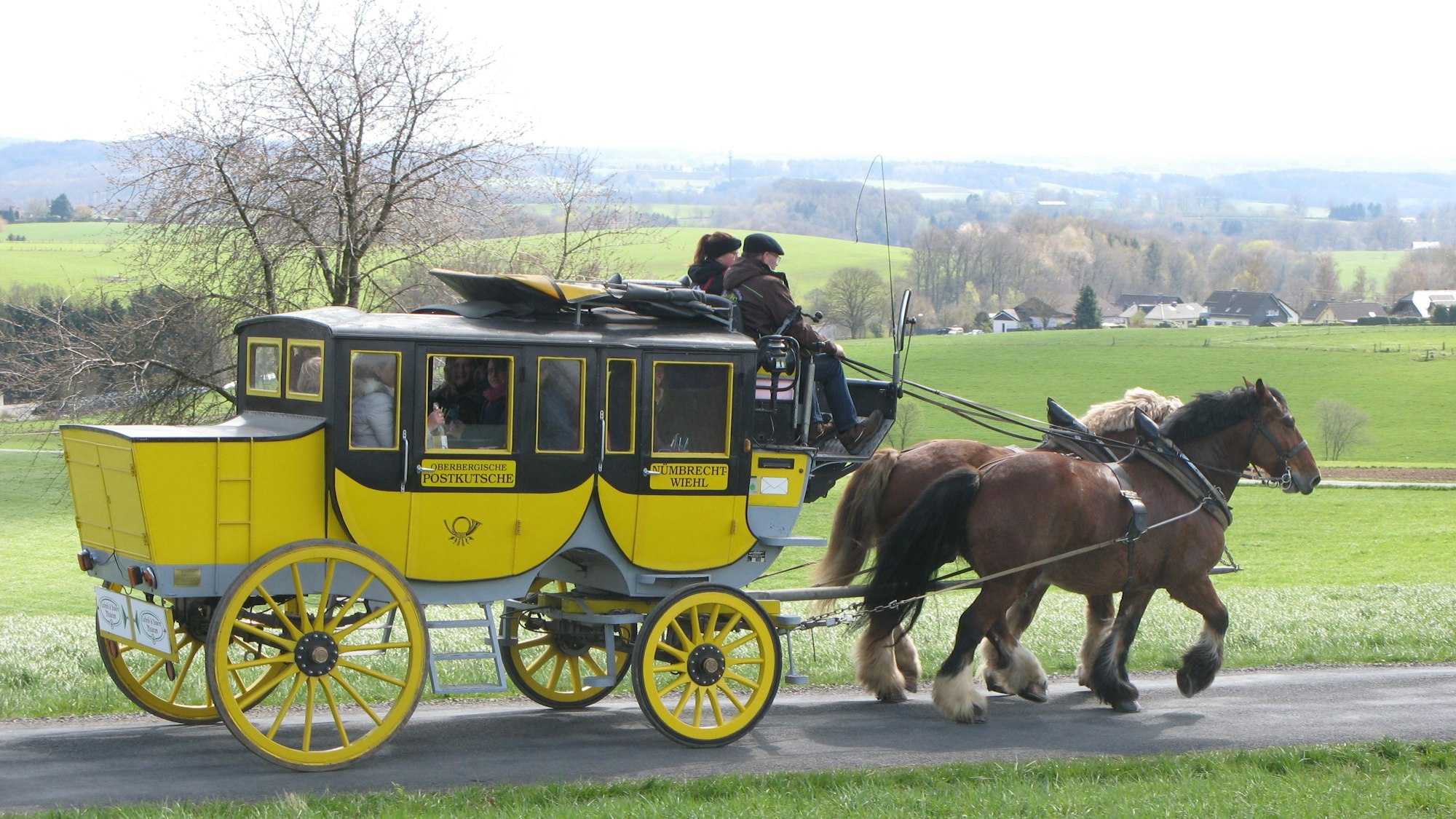 Eine historische Postkutsche, gezogen von zwei Kaltblutpferden.