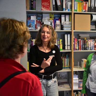 Zwei Frauen stehen vor einem Regal in einem Büro.