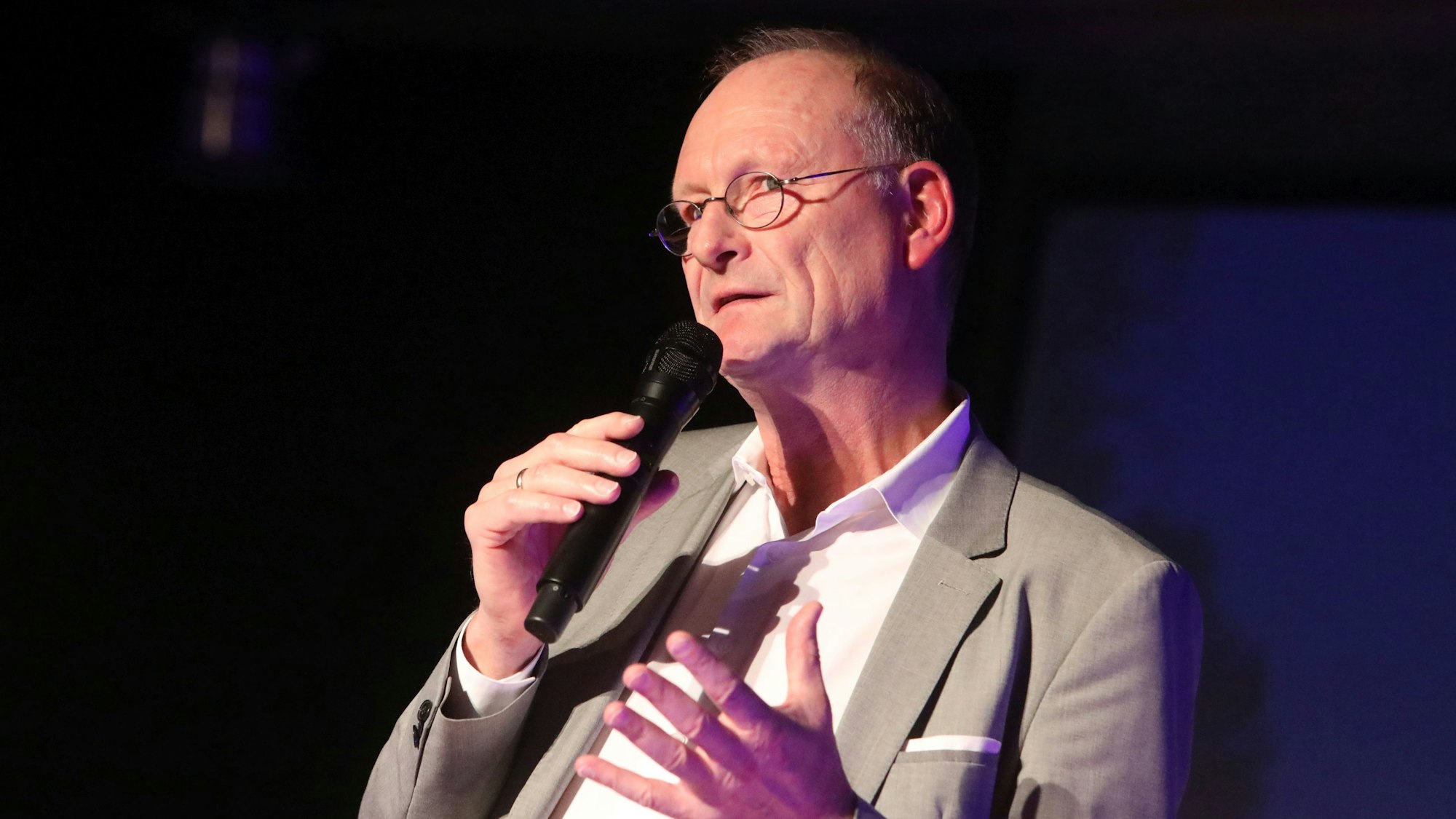 Ein Mann spricht in ein Mikrofon.