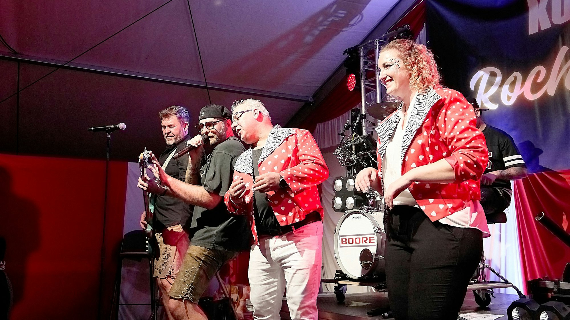 Drei Männer und eine Frau stehen auf der Bühne.