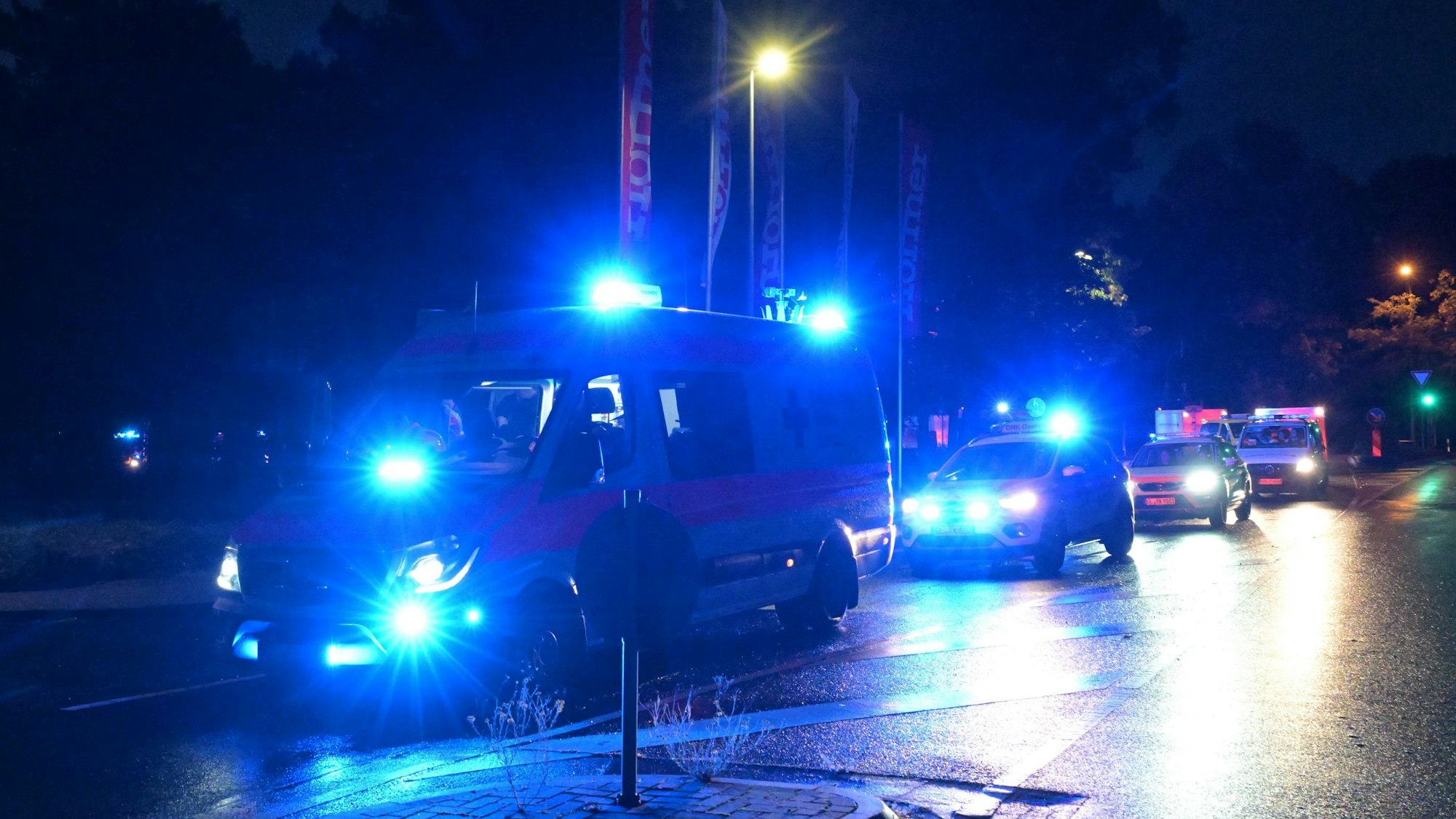 DRK-Fahrzeuge stehen mit Blaulicht auf einer Straße in Rösrath-Kleineichen.