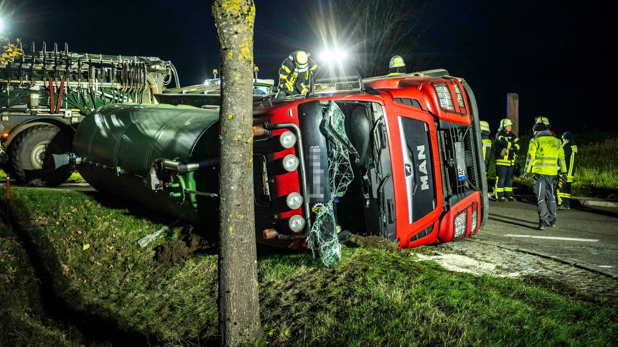 Der Laster liegt auf der Seite, Helfer sind im Einsatz.