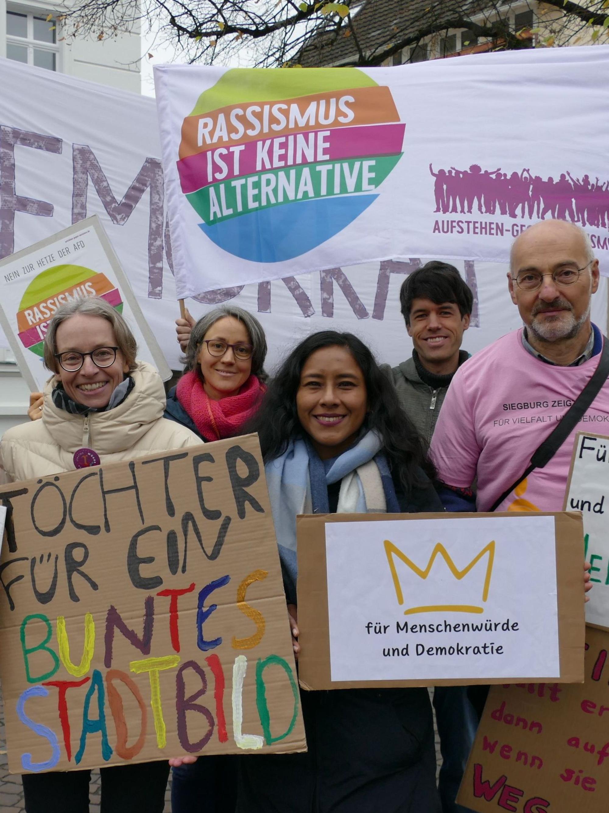Männer und Frauen mit Protestplakaten.