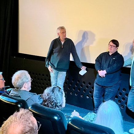 Zu sehen sind Hans-Jörg Blondiau, Clemente Fernandez-Gil und Nico Randel vor der Leinwand des Kinos.