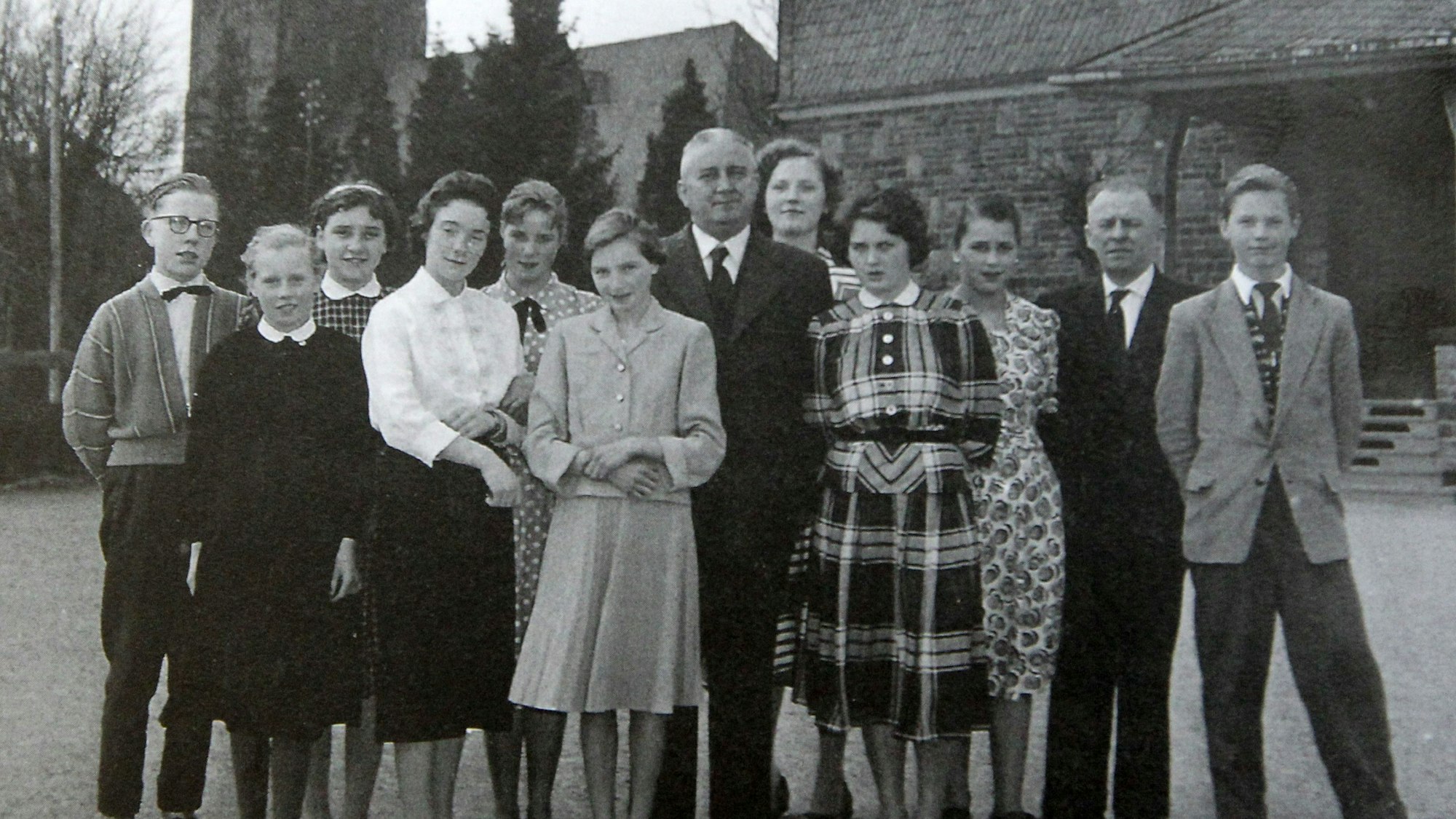 Ein Schwarz-Weiß-Gruppenfoto von formell gekleideten jungen Erwachsenen.