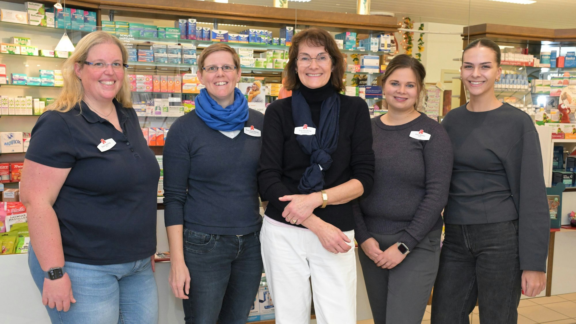 Fünf Frauen stehen vor Regalen mit Medikamenten in einer Apotheke.