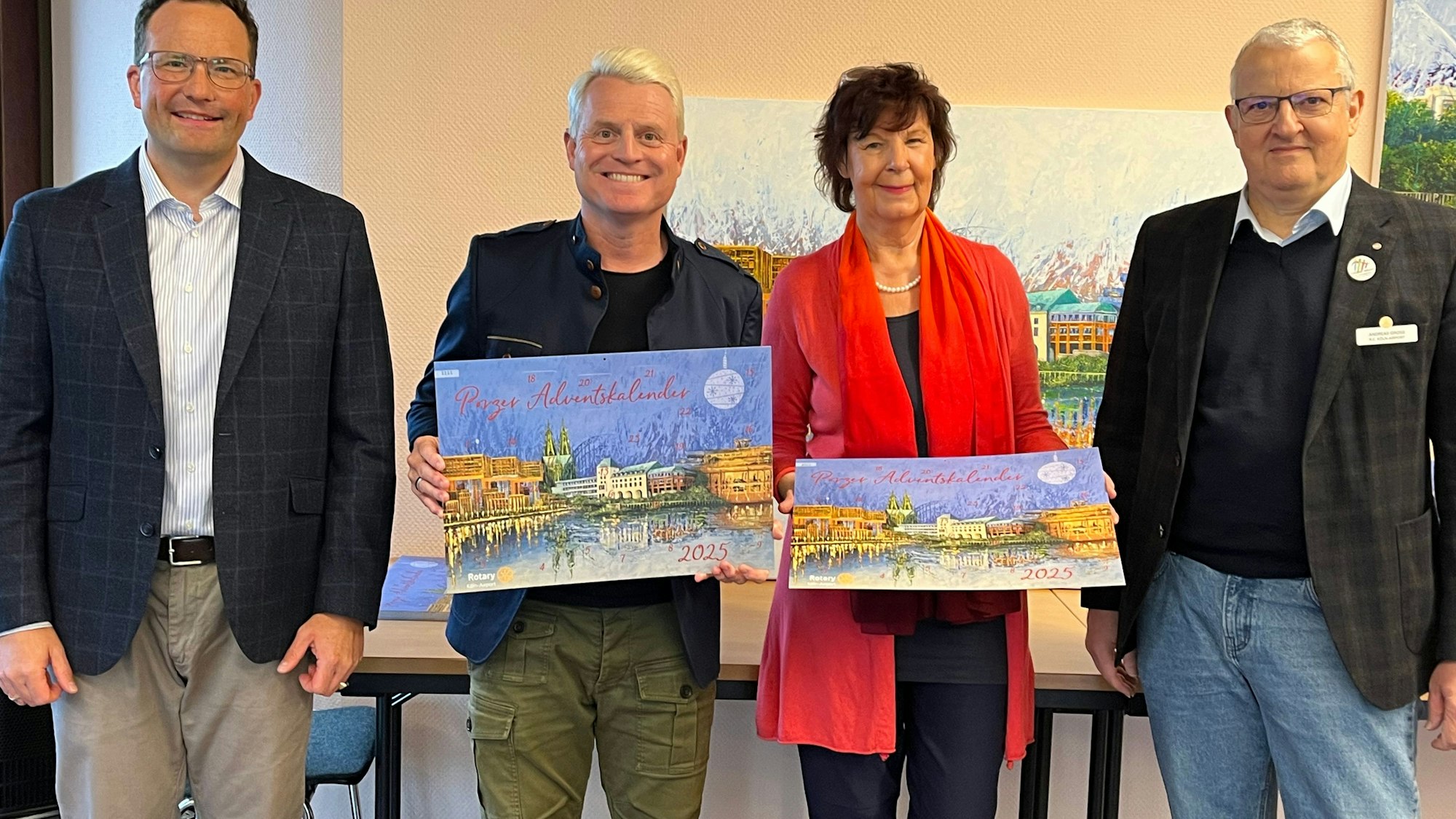 Drei Männer und eine Frau halten den aktuellen Adventskalender der Rotarier.