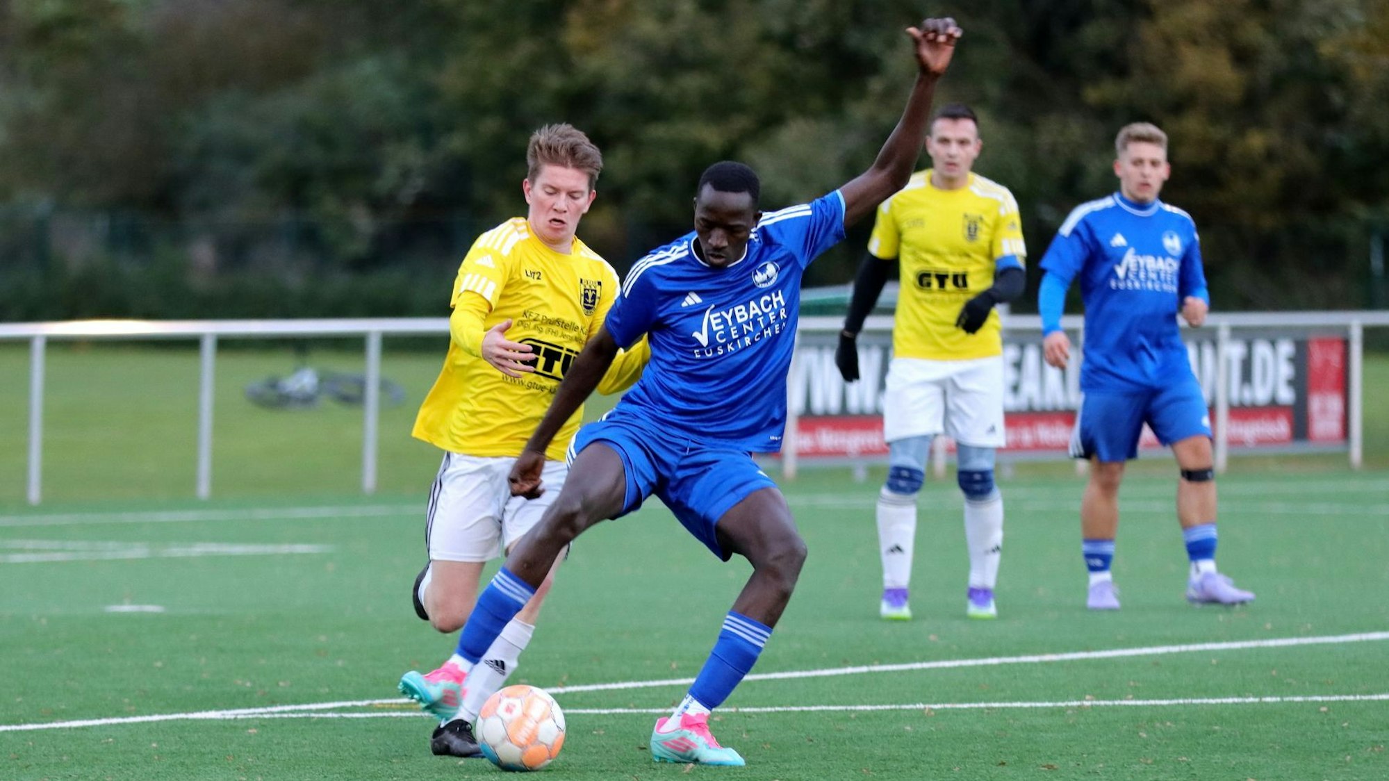 Ein Weilerswister Stürmer ist am Ball und deckt ihn vor dem heraneilenden Verteidiger von Golbach ab.