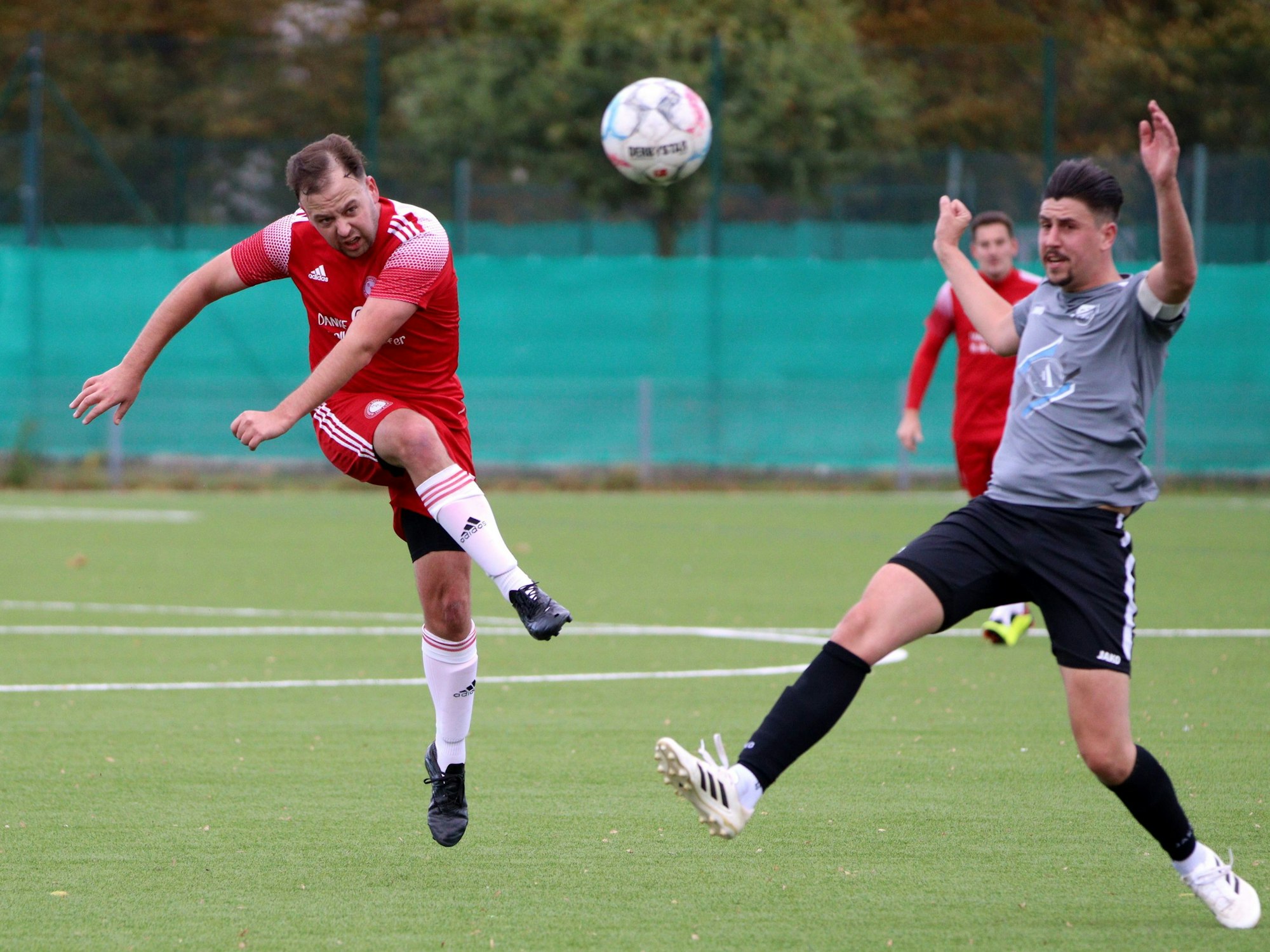 Nach dem Schuss steht Pascal Busch in der Luft. Tobias Weiß macht einen Ausfallschritt.
