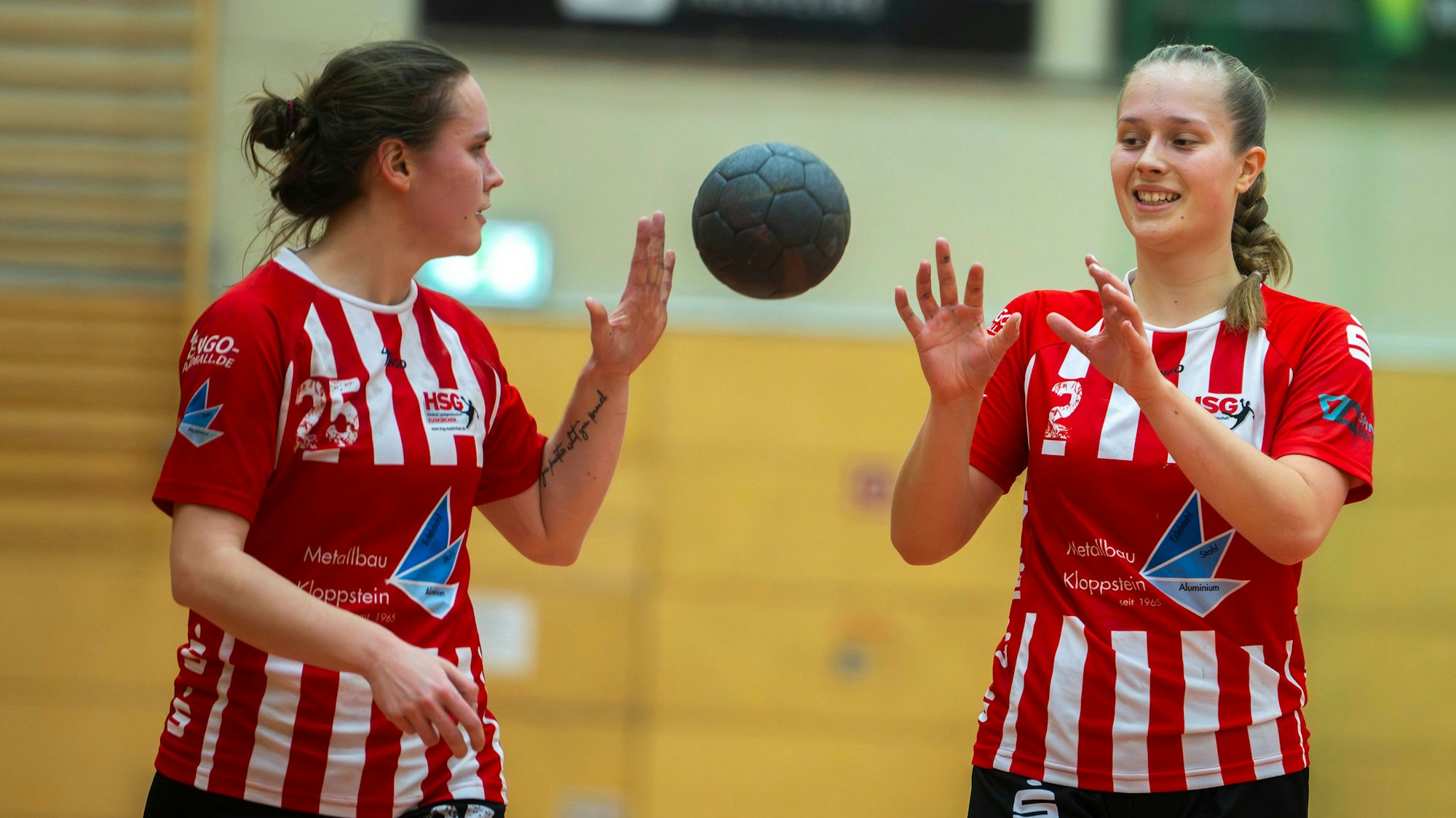 Zwei Spielerinnen der HSG Euskirchen werfen sich locker einen Ball zu.