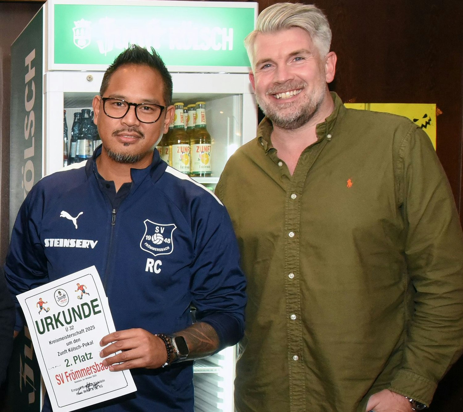 Ein Fußballer und der Chef der Erzquell-Brauerei schauen in die Kamera.