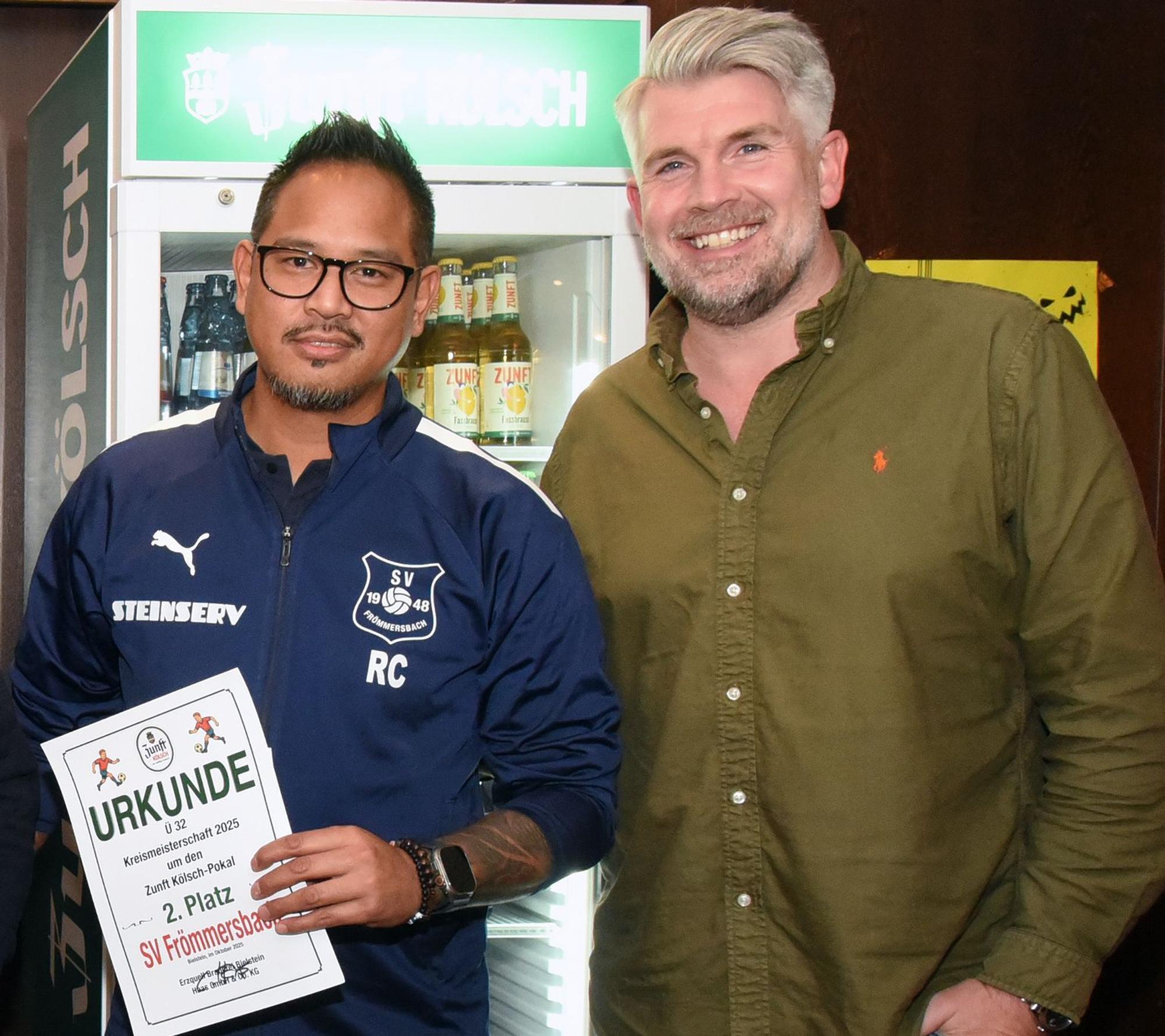 Ein Fußballer und der Chef der Erzquell-Brauerei schauen in die Kamera.