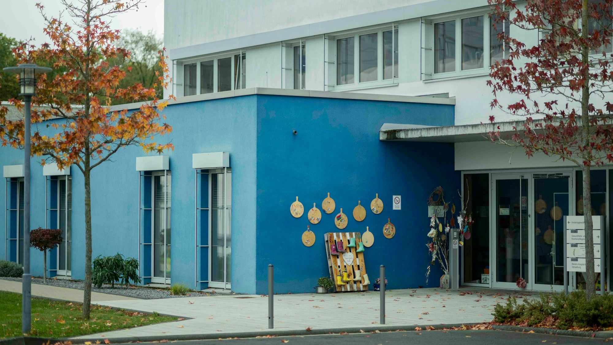 Das Bild zeigt den eingeschossigen Kita-Bau, der in einem höheren Gebäude untergebracht ist.