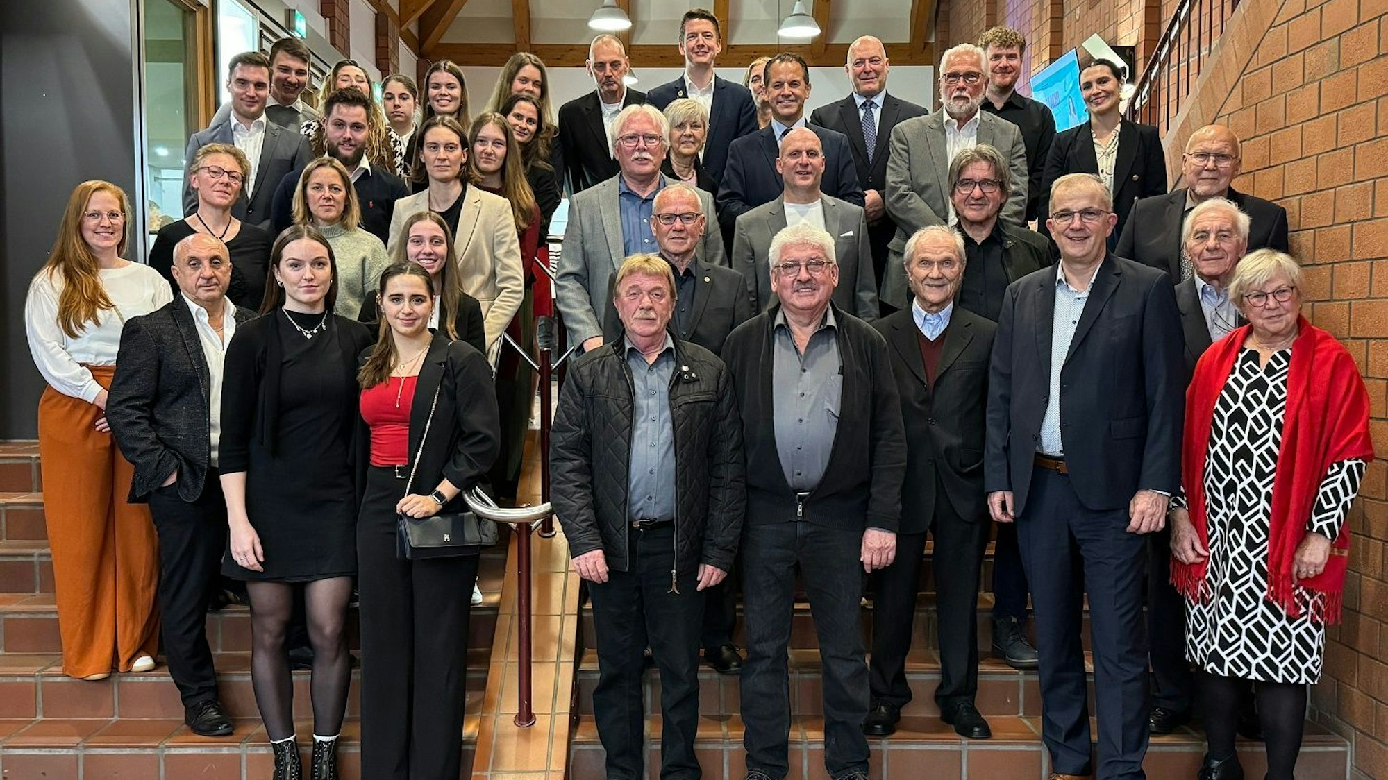 Dutzende Frauen und Männer stehen auf einer Treppe.