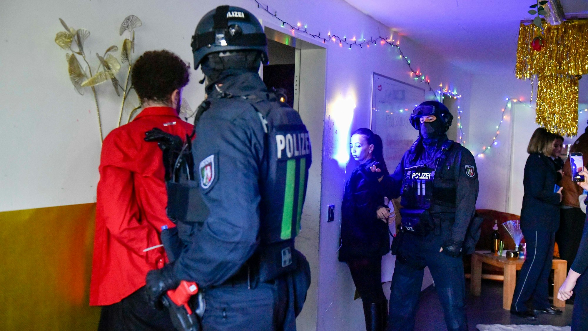 Polizisten nehmen eine Frau und einen Mann fest.