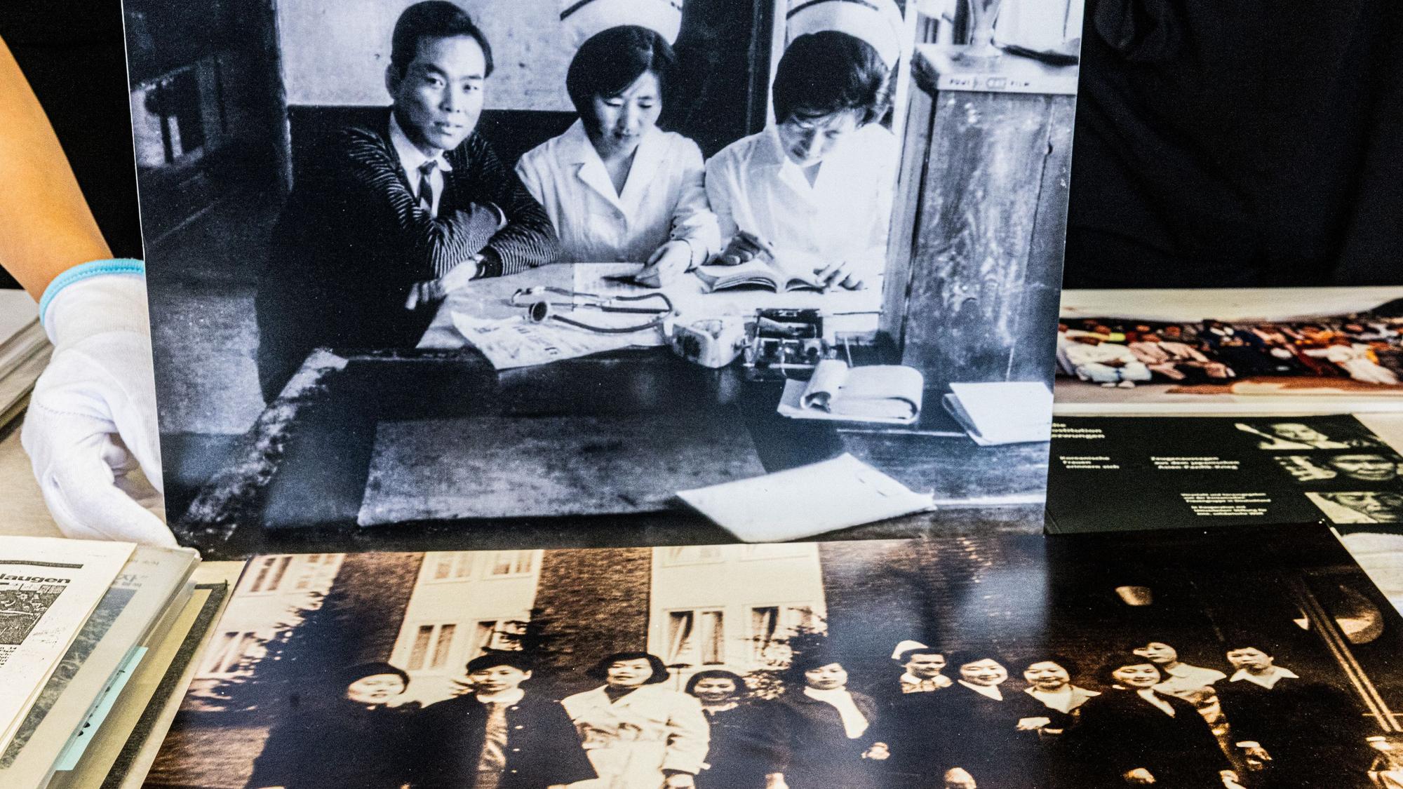 Die historischen Fotografien zeigen koreanische Pflegekräfte in Korea und in Deutschland. Frau An-Mäckler als examinierte koreanische Krankenschwester bei der Arbeit in Korea und koreanische Pflegekräfte nach ihrer Ankunft in Deutschland.