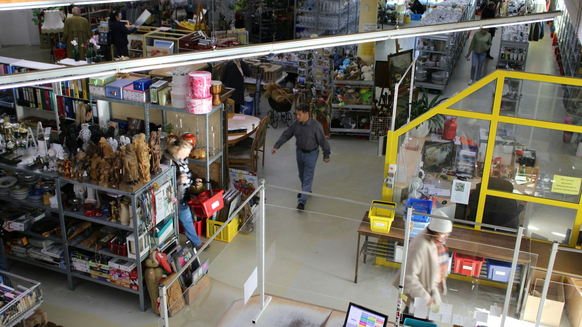 Ein Geschäft von oben: Kunden stöbern zwischen Geschirr und Gläsern, Bürobedarf, Spielsachen und mehr.