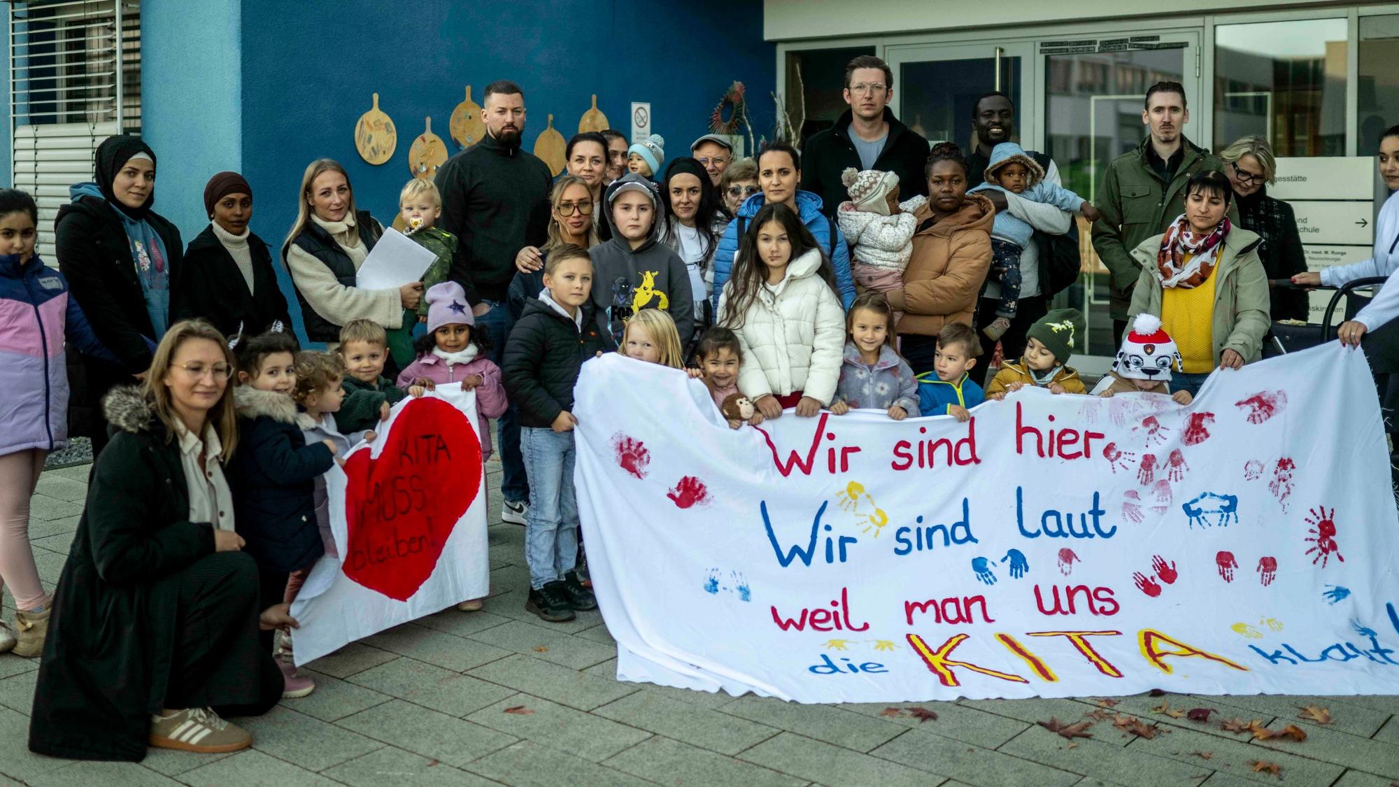 Das Bild zeigt Kinder und Erwachsene mit Protestbannern.