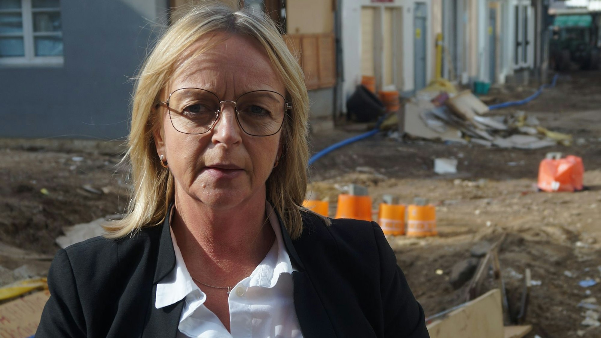 Sabine Preiser-Marian steht wenige Tage nach der Flutkatastrophe auf einer zerstörten Straße in Bad Münstereifel.