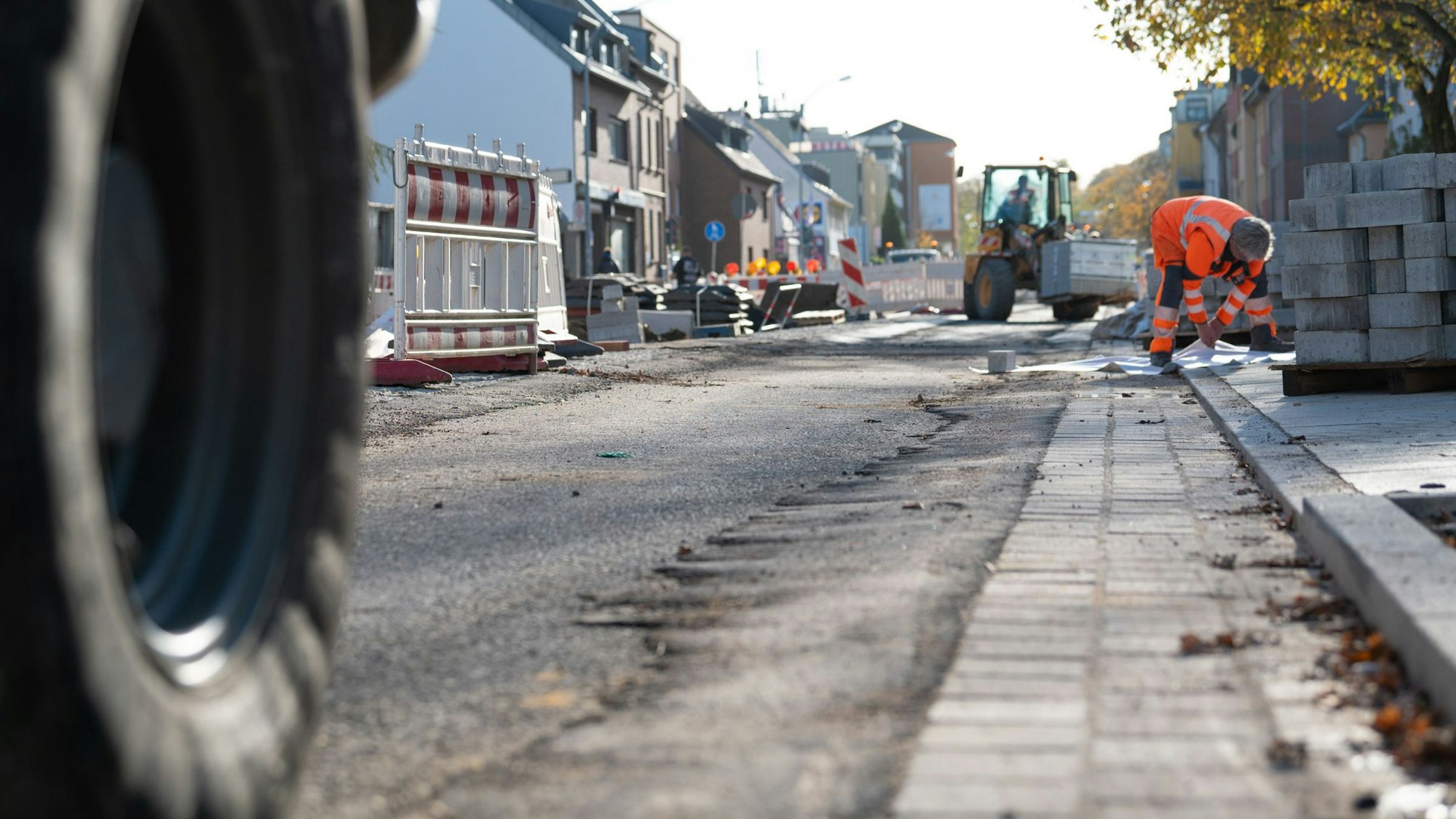 Ein Mann verlegt Steine für einen Gehweg.