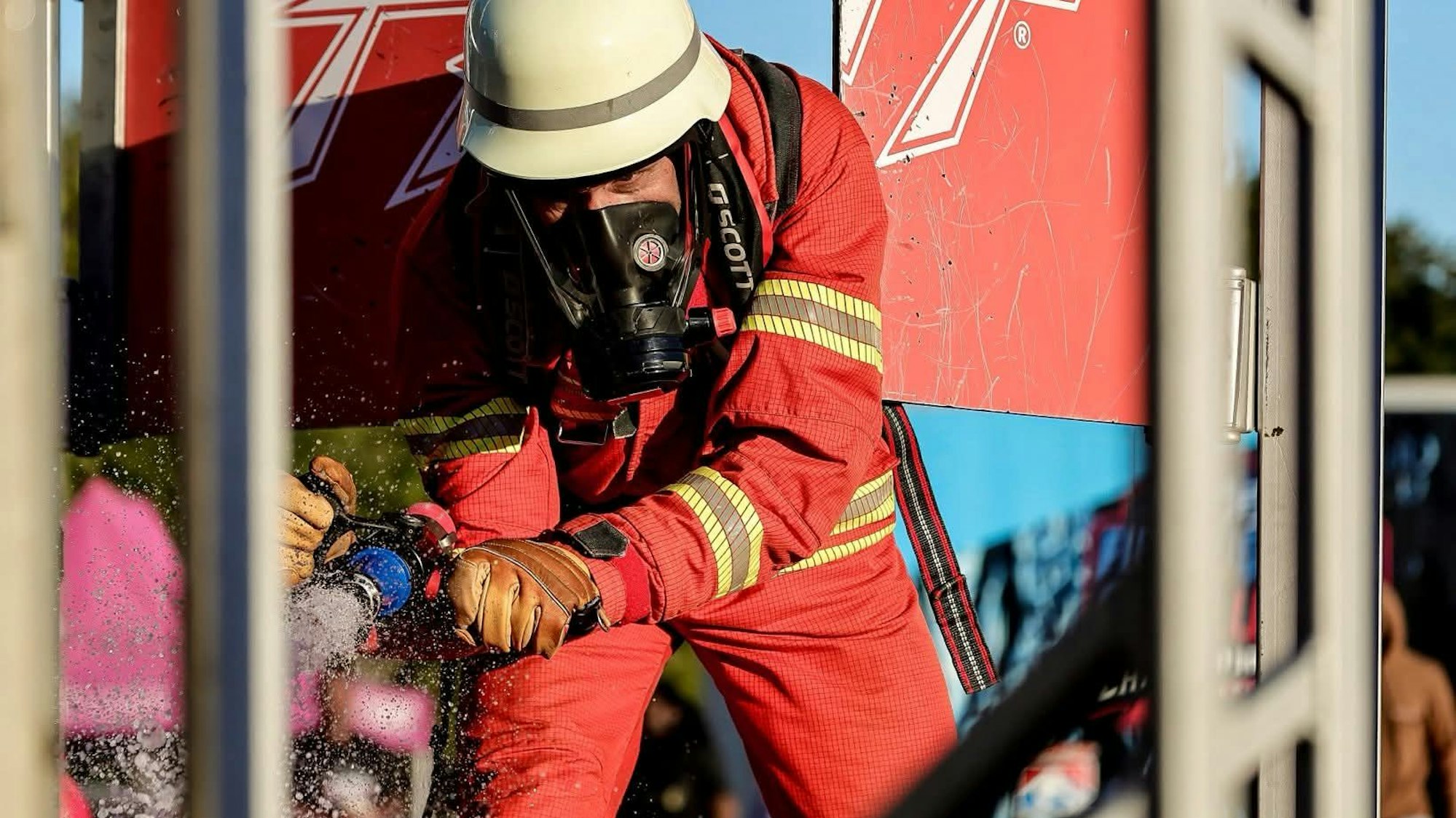 Ein Feuerwehrmann in roter Einsatzkleidung.