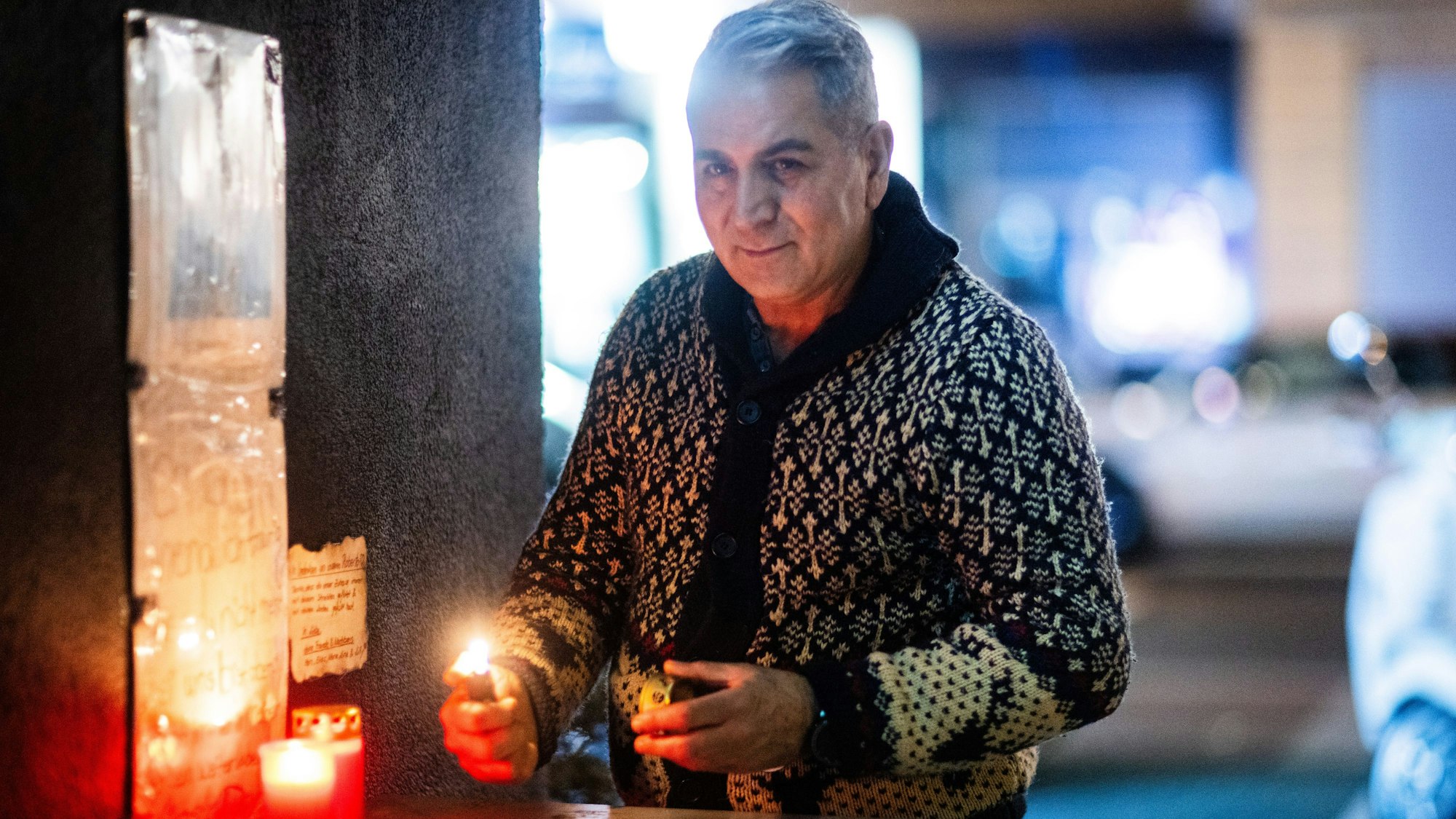 In Ehrenfeld zündet Kioskbesitzer Mohammad Hossein Resalati Kerzen für einen verstorbenen obdachlosen Kunden an.
