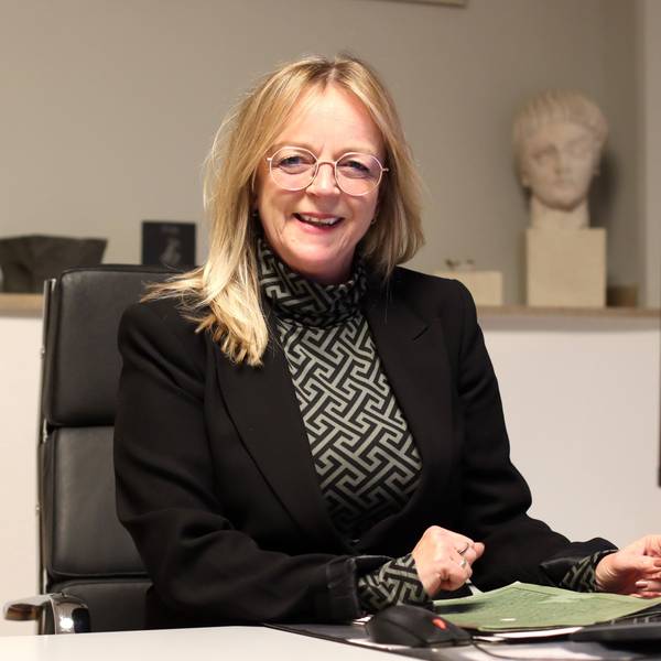 Sabine Preiser-Marian sitzt an einem Schreibtisch.