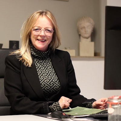 Sabine Preiser-Marian sitzt an einem Schreibtisch.