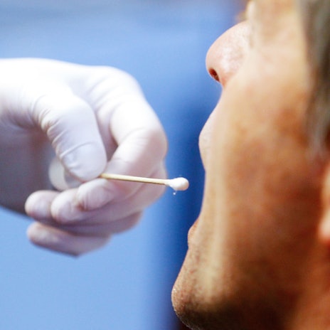 Die Polizei führt einen DNA-Speicheltest bei einem Mann (Polizist) in einem Mordfall durch.