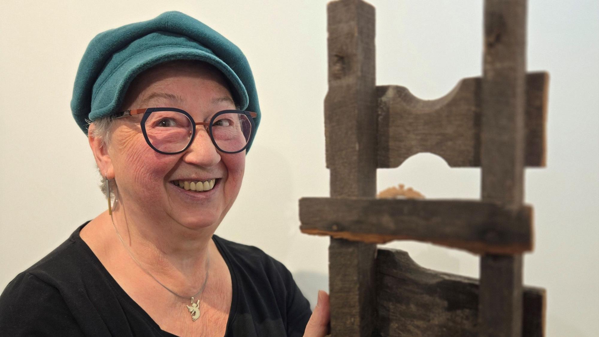 Ein Dame hält ein Holzobjekt.