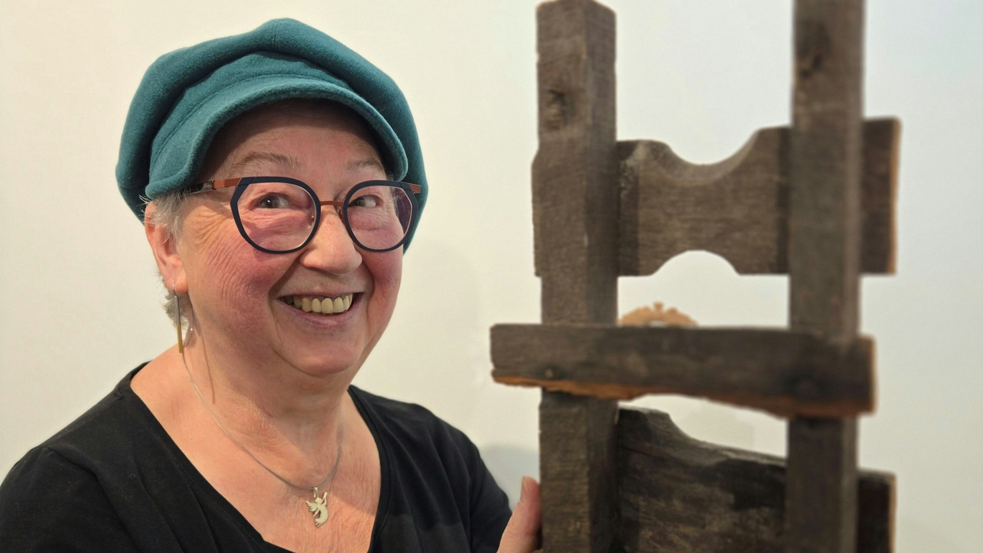 Ein Dame hält ein Holzobjekt.