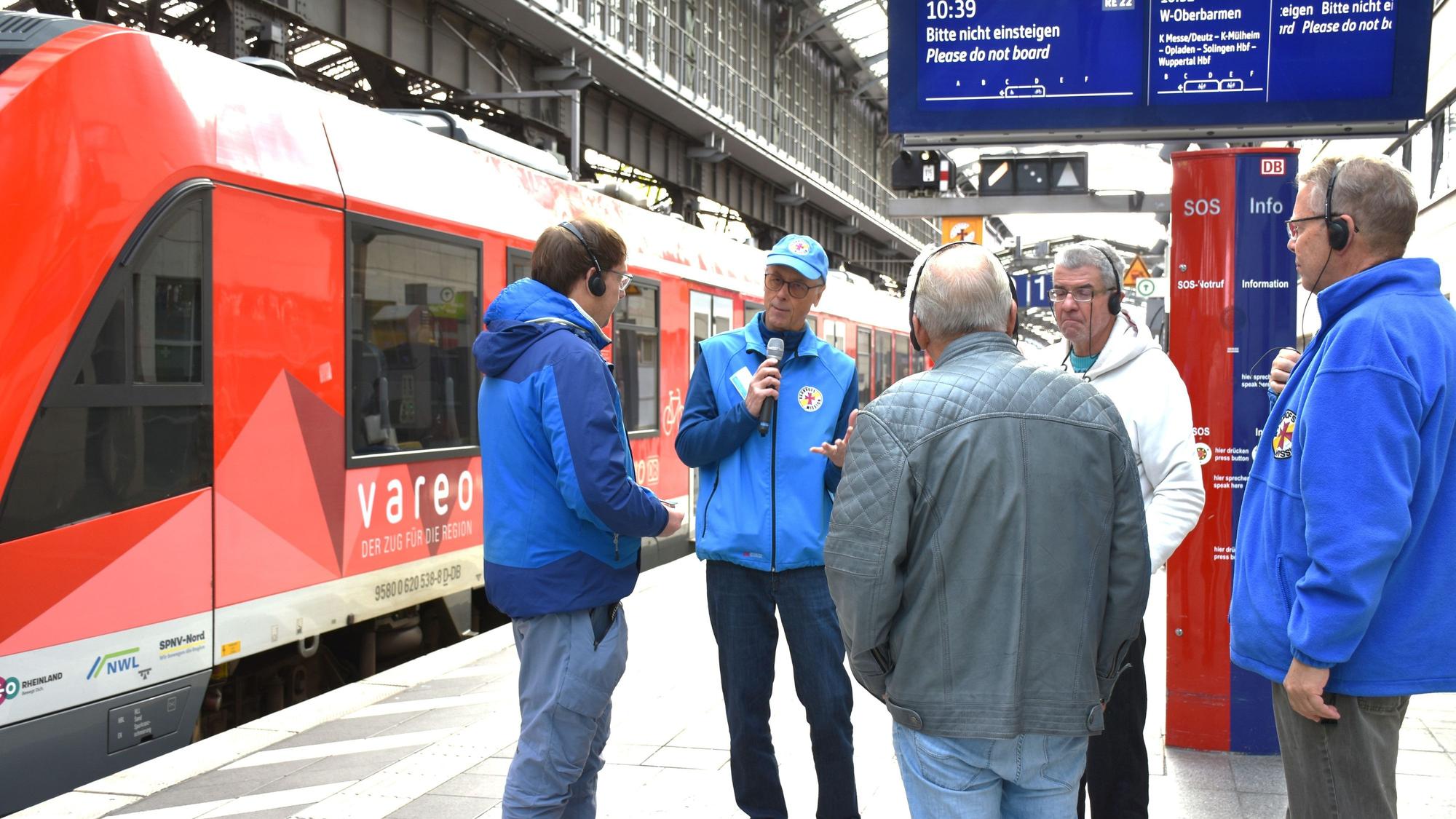 Wie lese ich die digitalen Anzeigen richtig? Die Bahnhofsmission führt Senioren durch den Kölner Hbf.