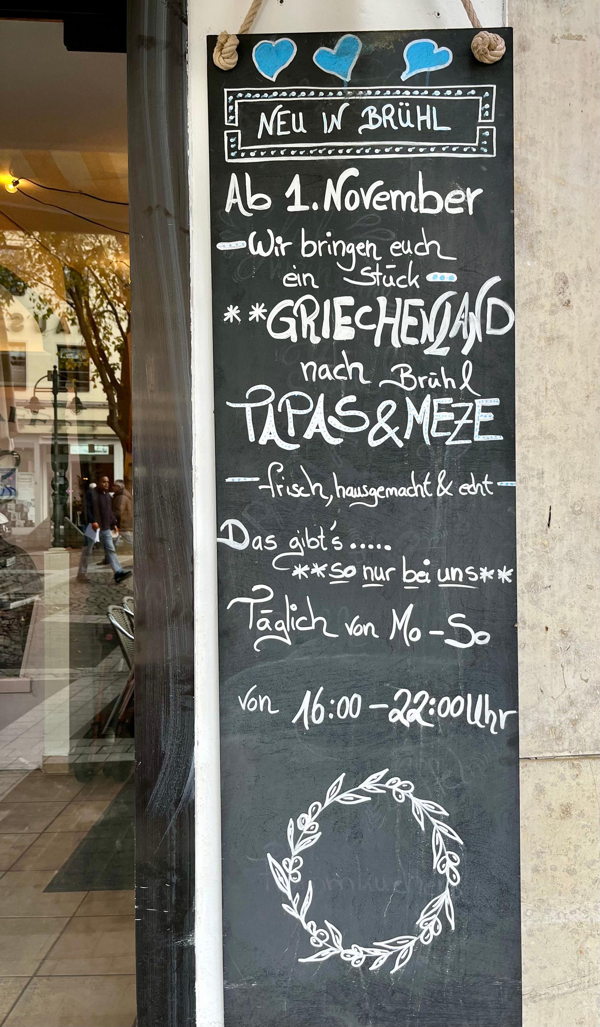 An der Wand ihres „Rosa Caffé“ wirbt Evelina Bennardo für ihr neues Konzept am Abend mit einer griechischen Küche.