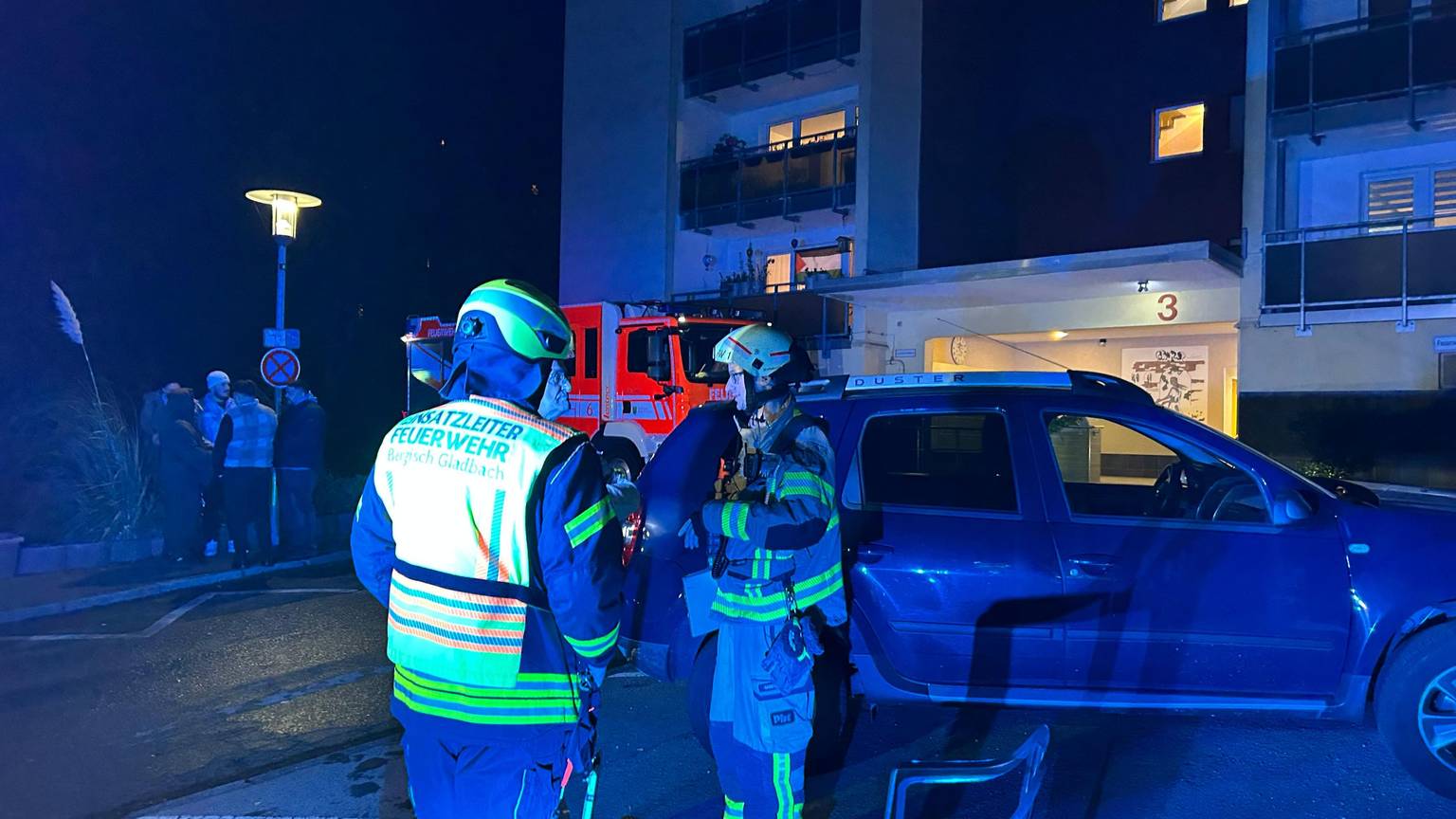 Feuerwehrleute stehen vor einem Haus an der Marienhöhe in Bergisch Gladbach.