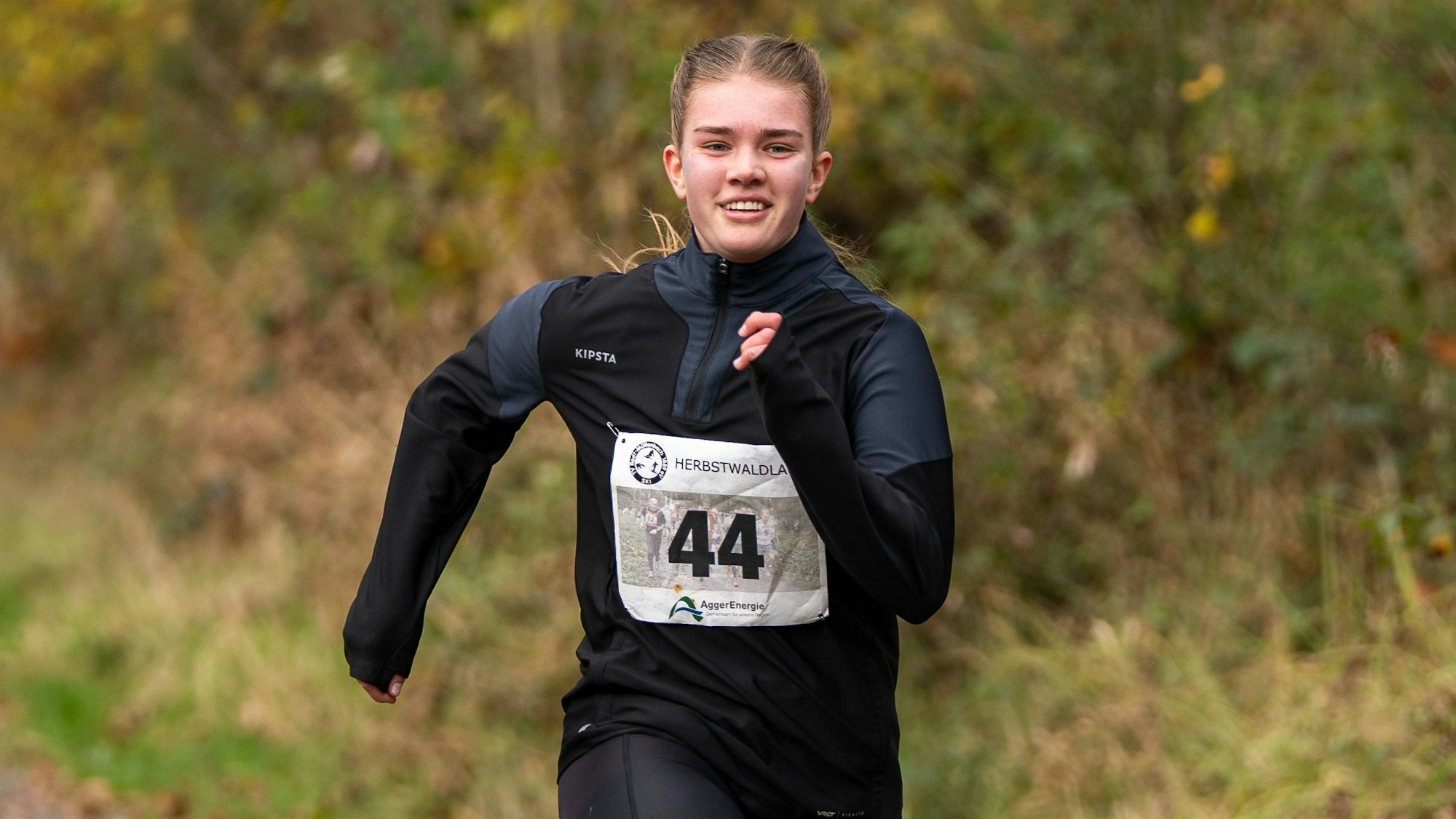 Zu sehen ist eine junge Frau beim Waldlauf.