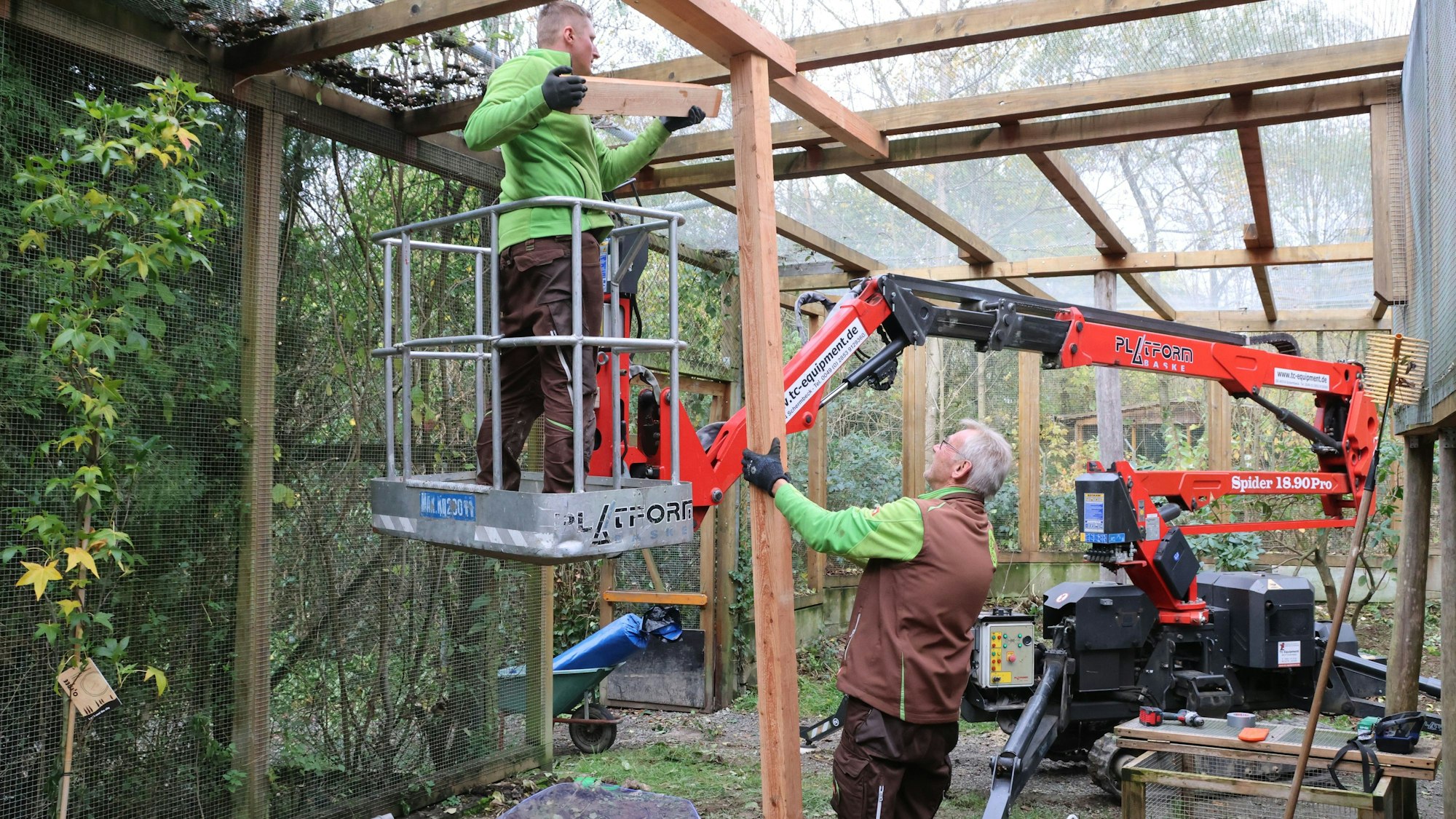 Das Bild zeigt Mitarbeiter, die die Schleuse in ein Vogelgehege verstärken.
