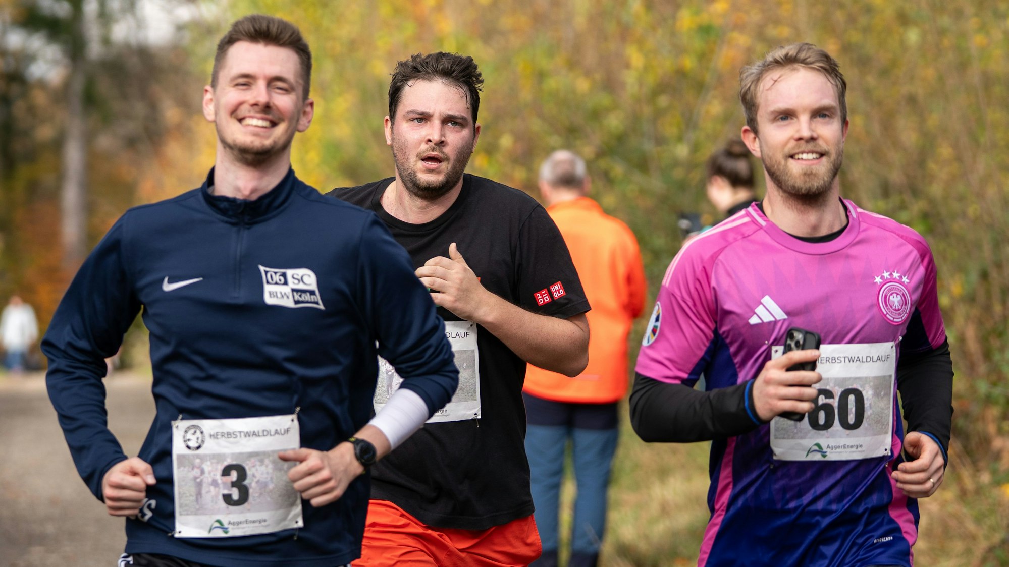 Drei Läufer beim Waldlauf.