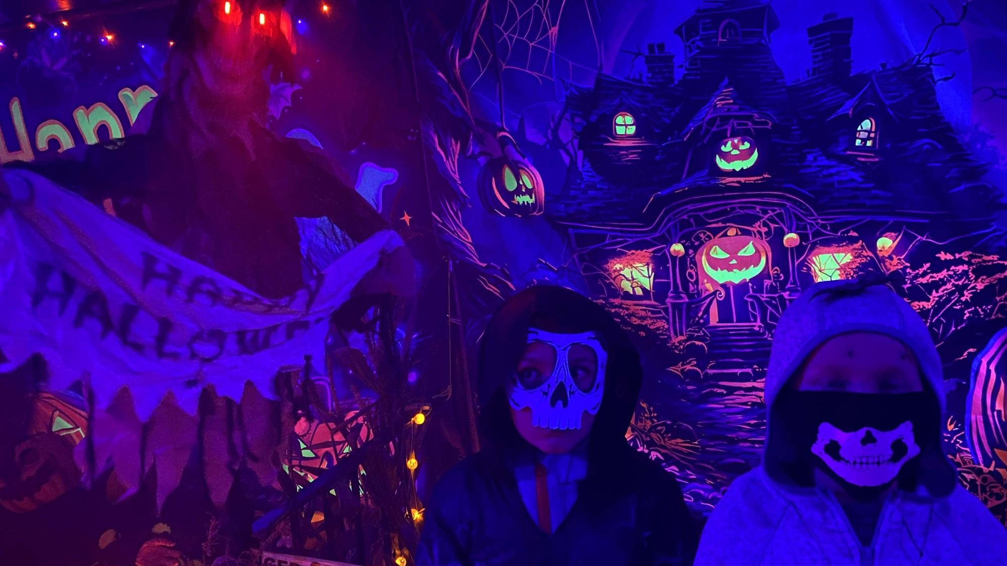 Kinder mit Skelettmasken durchstreifen das Gruselhaus.