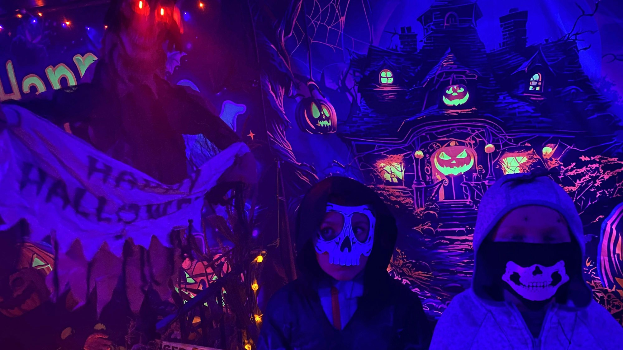 Kinder mit Skelettmasken durchstreifen das Gruselhaus.